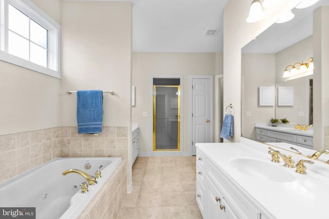 bathroom featuring plus walk in shower, vanity, and tile patterned flooring