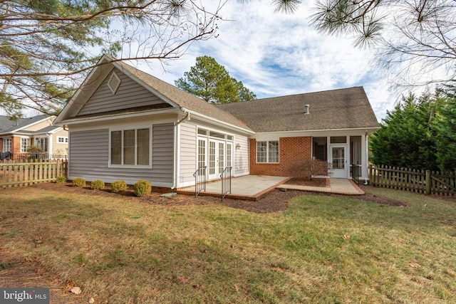 rear view of property with french doors, a patio area, and a lawn