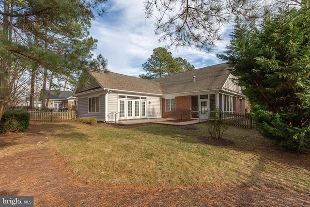 back of house featuring a yard, a patio area, a sunroom, and french doors