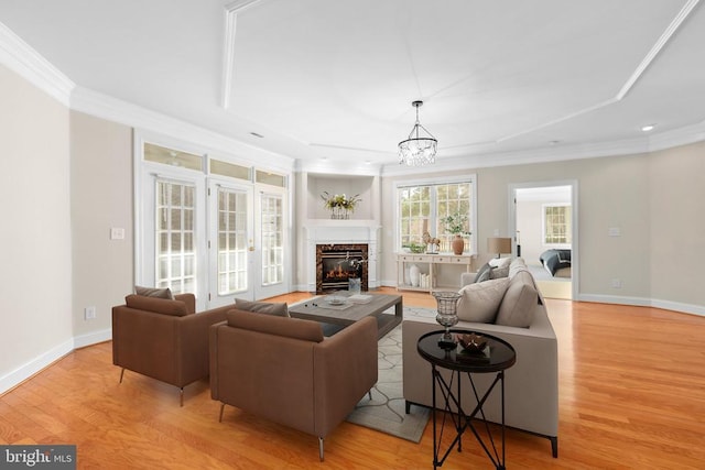 living room with light hardwood / wood-style flooring, a chandelier, and ornamental molding