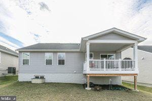 back of house with a lawn and central AC