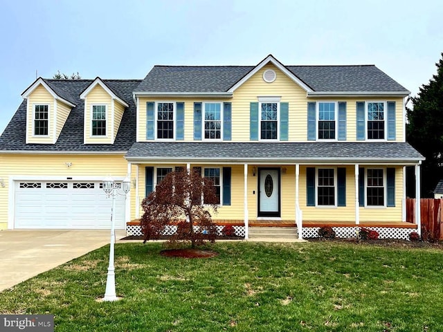 view of front facade with a front yard, a porch, and a garage