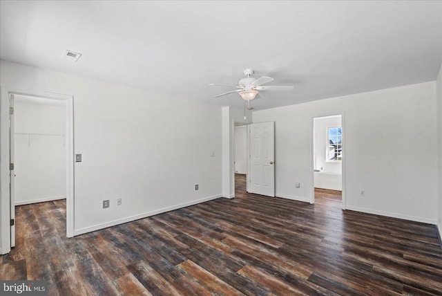 empty room with ceiling fan and dark hardwood / wood-style flooring