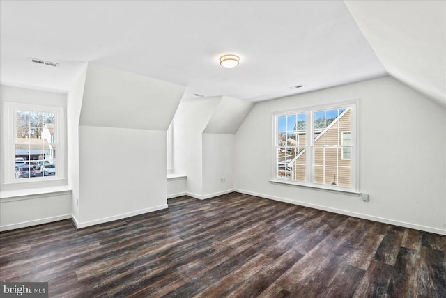 additional living space featuring vaulted ceiling and dark hardwood / wood-style floors