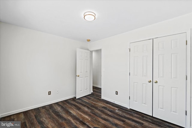 unfurnished bedroom with a closet and dark hardwood / wood-style floors