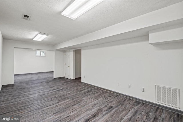 basement featuring a textured ceiling and dark wood-type flooring