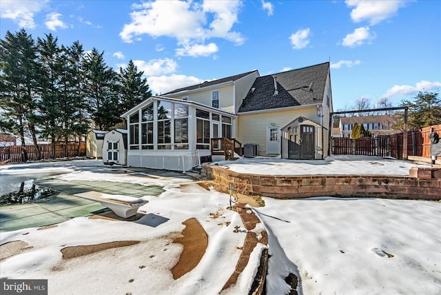 back of property with a pergola, a sunroom, a storage shed, and central AC unit