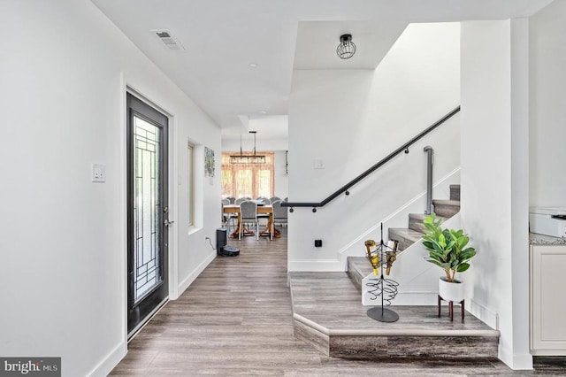 entrance foyer with a notable chandelier and light hardwood / wood-style floors