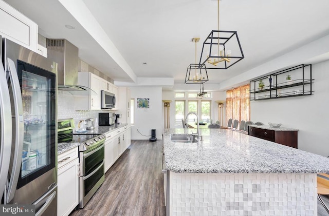 kitchen featuring an island with sink, sink, white cabinets, and stainless steel appliances