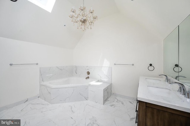 bathroom with vanity, vaulted ceiling with skylight, a relaxing tiled tub, and a notable chandelier