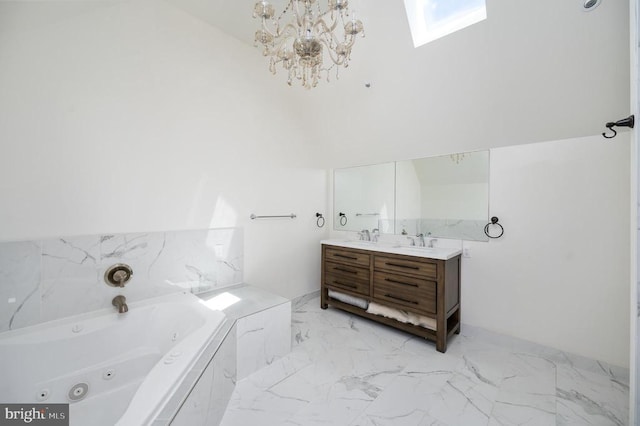 bathroom with a notable chandelier, a bathtub, vanity, and a skylight