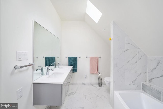 bathroom featuring vanity, toilet, a bathtub, and vaulted ceiling with skylight