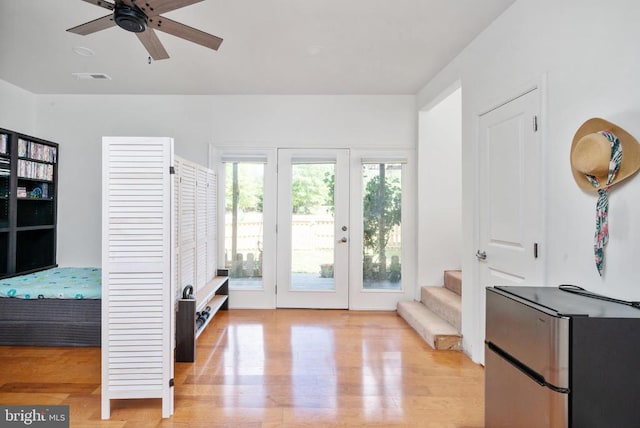 doorway with light hardwood / wood-style flooring and ceiling fan