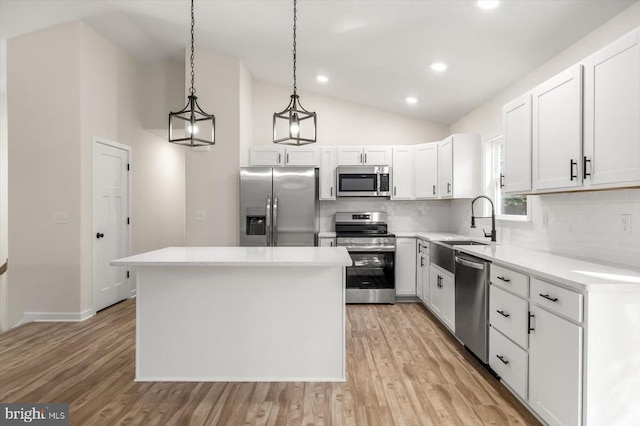 kitchen featuring a kitchen island, white cabinets, decorative light fixtures, and appliances with stainless steel finishes