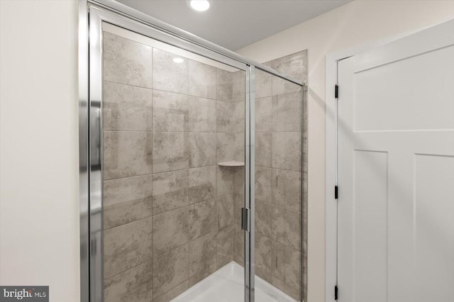 bathroom with a shower with door