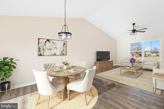 dining area featuring ceiling fan with notable chandelier, dark hardwood / wood-style floors, and lofted ceiling