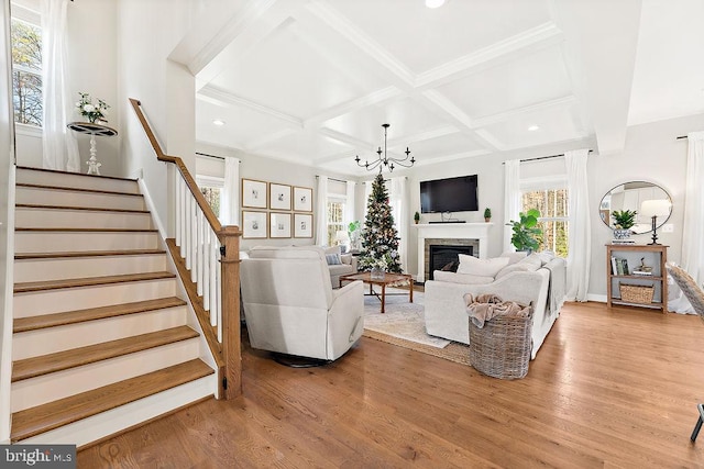 living room featuring beam ceiling, hardwood / wood-style floors, coffered ceiling, and an inviting chandelier