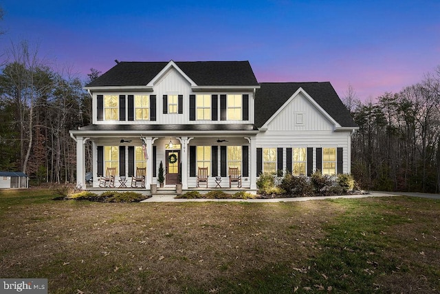 view of front facade with a lawn, ceiling fan, and a porch