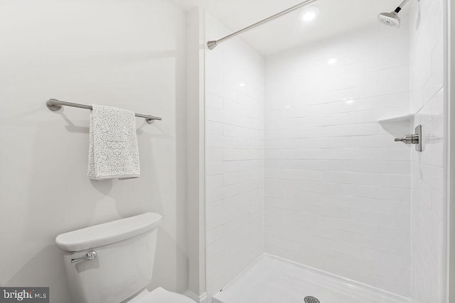 bathroom featuring toilet and a tile shower