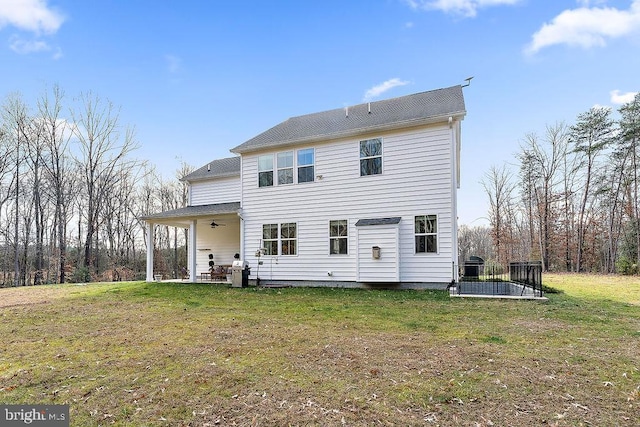 rear view of property with a yard and ceiling fan