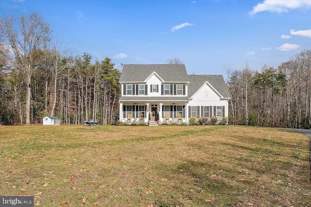 view of front of property with a porch, a storage shed, and a front lawn