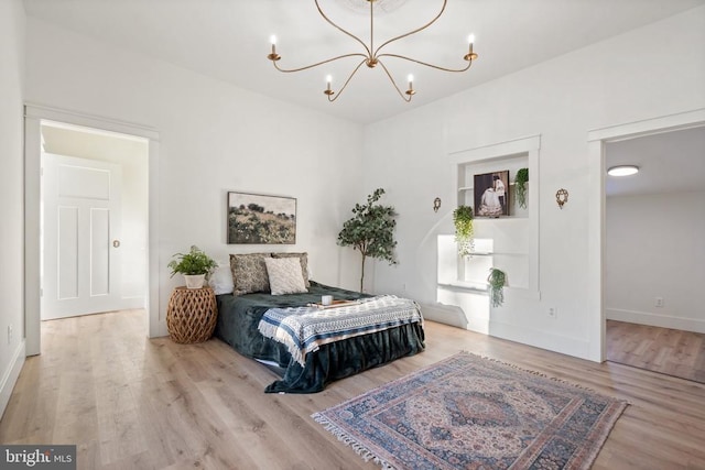 bedroom featuring light wood-type flooring and a chandelier