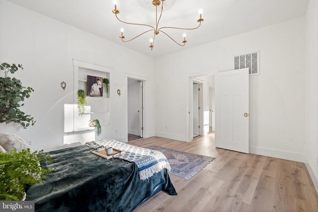 bedroom with light hardwood / wood-style flooring and a chandelier