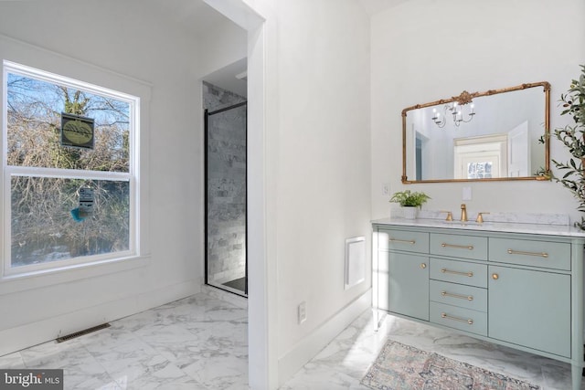 bathroom with vanity, a shower with shower door, and a notable chandelier