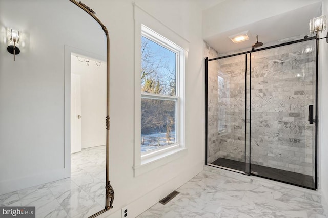 bathroom featuring plenty of natural light and a shower with door