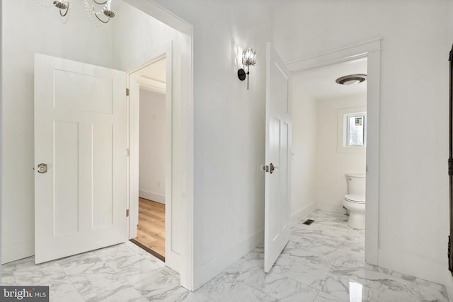 bathroom featuring toilet and a chandelier