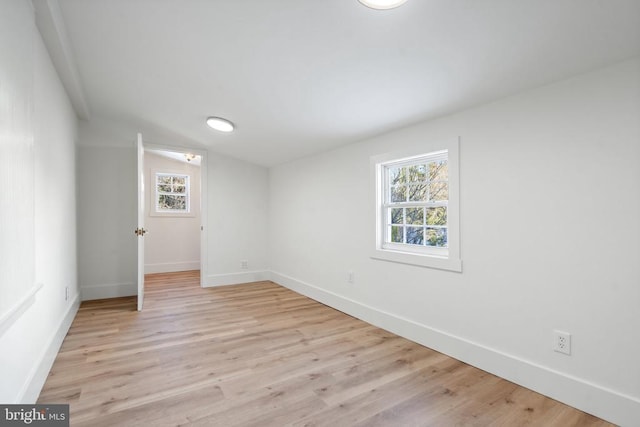 empty room featuring light wood-type flooring and lofted ceiling