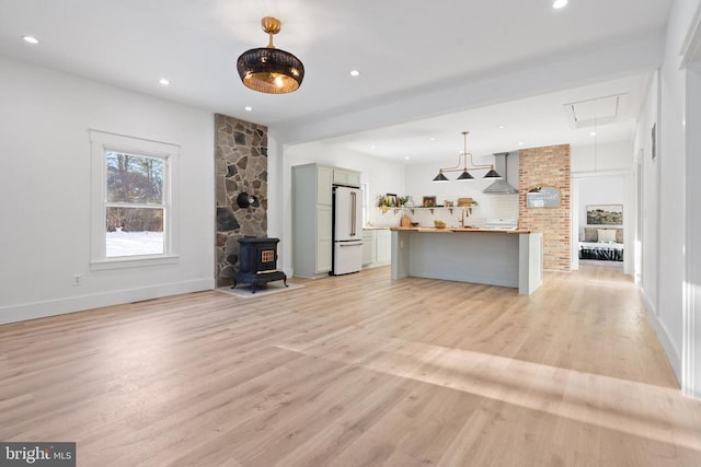 unfurnished living room featuring light hardwood / wood-style floors and a wood stove