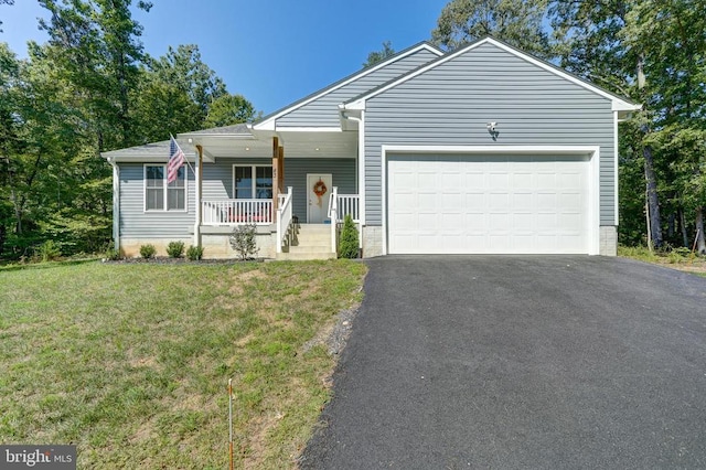 view of front of property featuring covered porch, a garage, and a front lawn