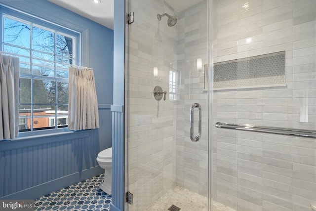 bathroom featuring toilet, tile patterned flooring, and a shower with door