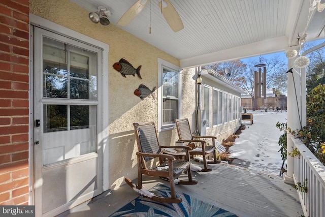 snow covered patio with covered porch and ceiling fan