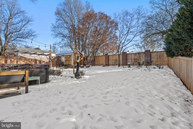 yard covered in snow featuring a hot tub