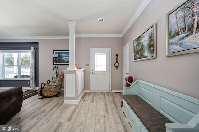 entryway featuring ornate columns, ornamental molding, and light hardwood / wood-style flooring