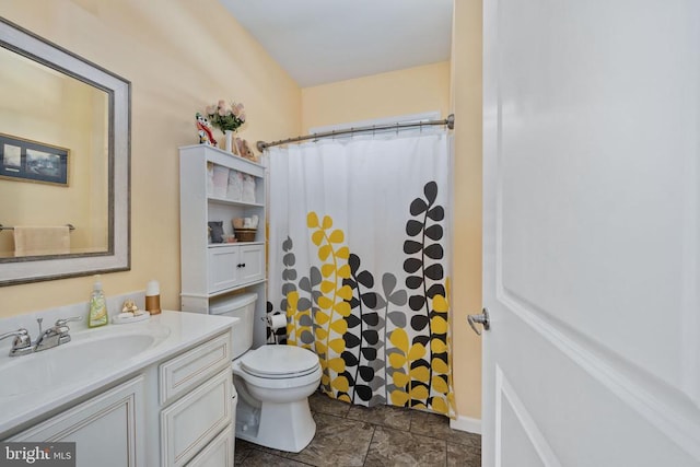 bathroom featuring toilet, walk in shower, and vanity