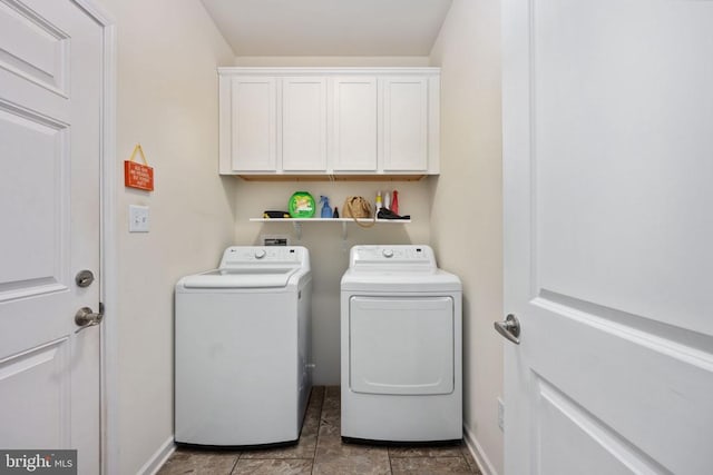 laundry area with washer and dryer, tile patterned flooring, and cabinets