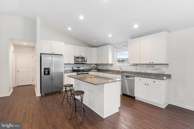 kitchen with tasteful backsplash, white cabinetry, a kitchen island, and appliances with stainless steel finishes