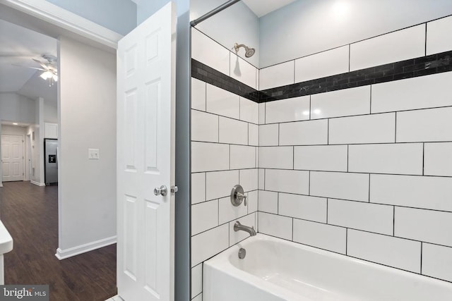 bathroom featuring tiled shower / bath combo, ceiling fan, and wood-type flooring