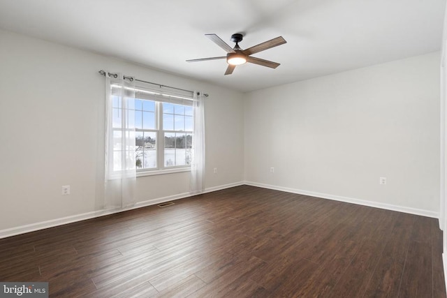 spare room featuring ceiling fan and dark wood-type flooring