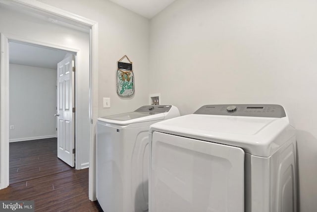 clothes washing area with dark hardwood / wood-style floors and washing machine and clothes dryer