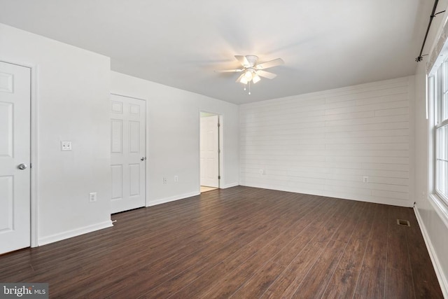 spare room with dark hardwood / wood-style floors and ceiling fan