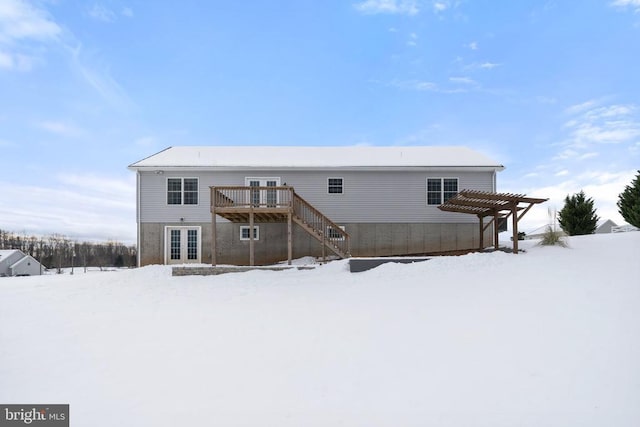 snow covered property featuring a pergola, a wooden deck, and french doors