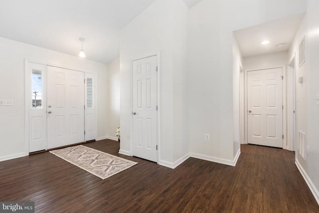 entrance foyer with dark hardwood / wood-style floors and vaulted ceiling