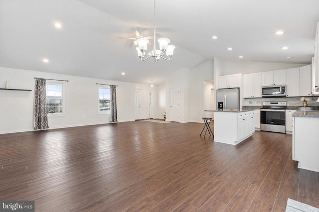 kitchen with white cabinetry, a kitchen breakfast bar, dark hardwood / wood-style flooring, a kitchen island, and appliances with stainless steel finishes