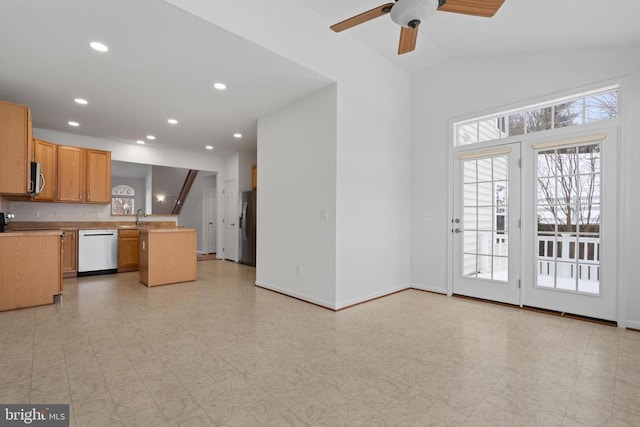 kitchen featuring ceiling fan, vaulted ceiling, decorative backsplash, sink, and appliances with stainless steel finishes