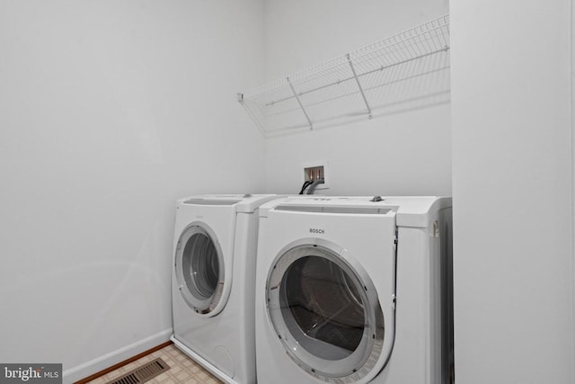 clothes washing area with washing machine and dryer