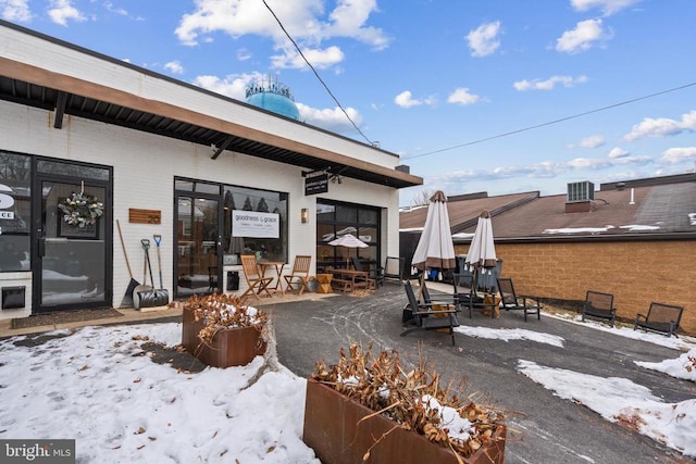 snow covered rear of property featuring an outdoor fire pit